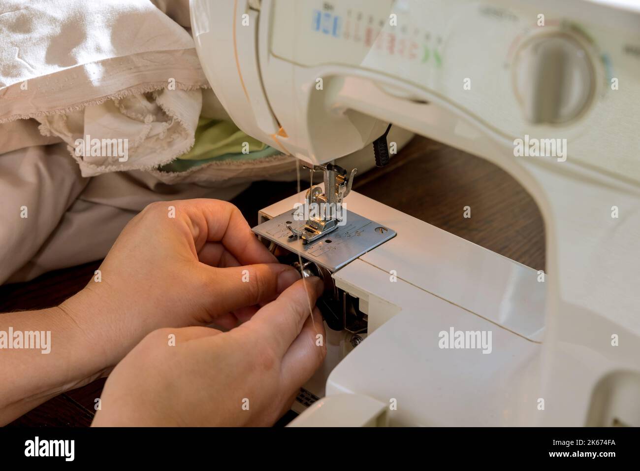 Pendant le processus de couture, la couture place les fils sur une bobine métallique dans la machine à coudre Banque D'Images