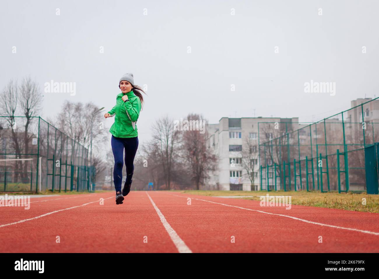 Jeune athlète de course sur le terrain de sport en automne. Portrait du corps entier. Un mode de vie actif et sain. Espace Banque D'Images