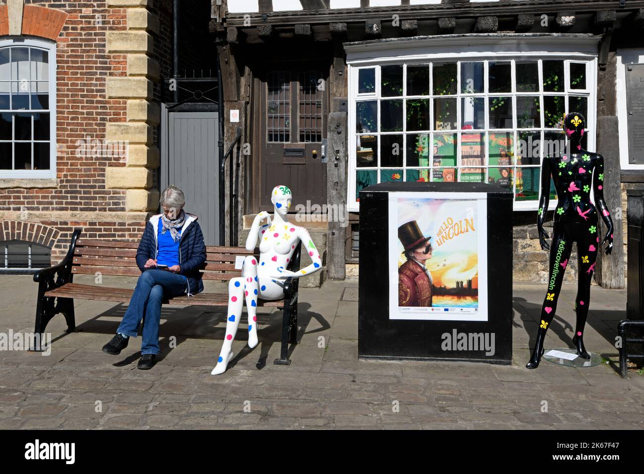 Une femme s'est assise sur un banc, avec une maquette de mannequin Banque D'Images