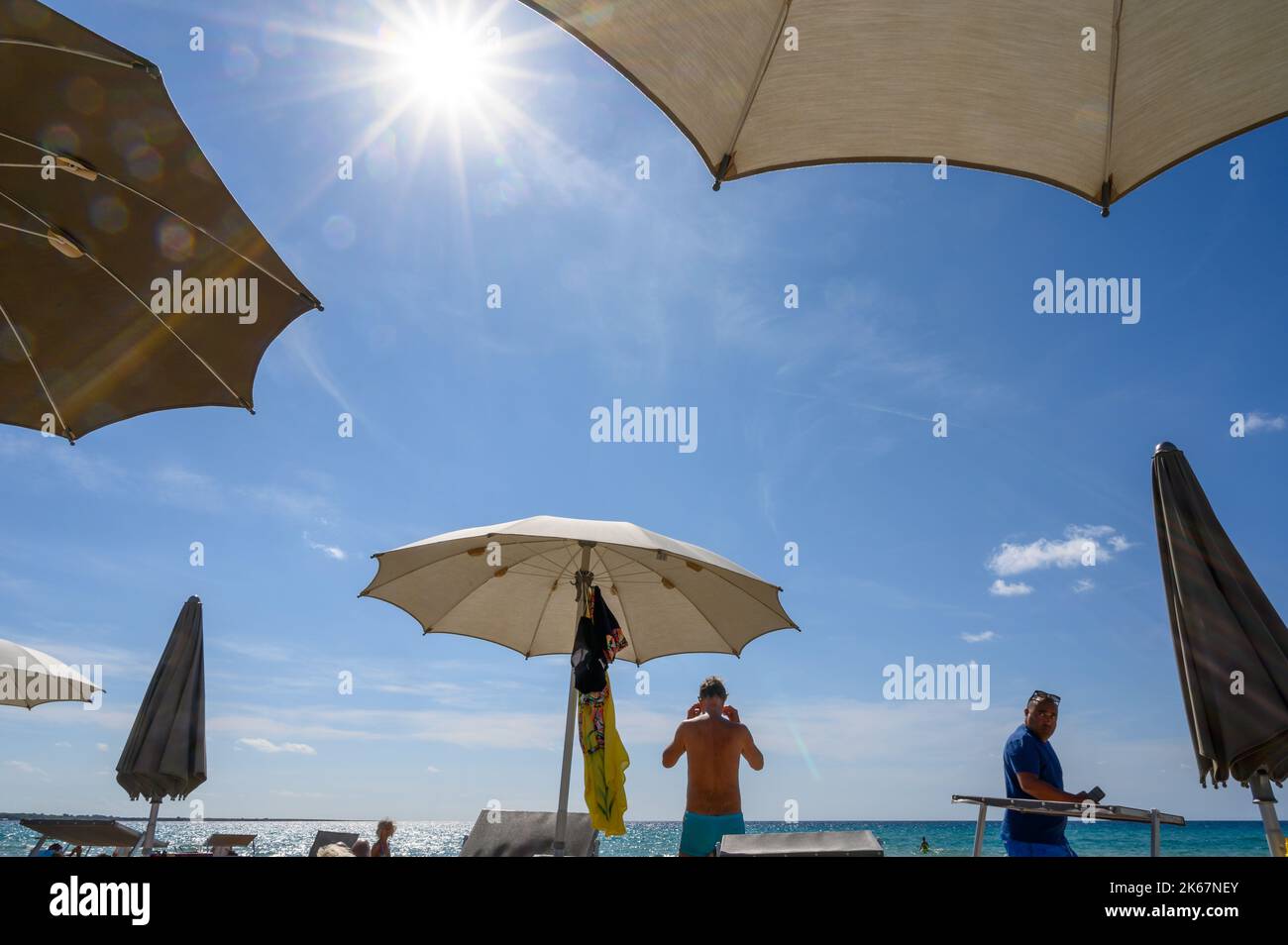 Bains de soleil et plage avec chaises longues et parasols sur la plage de Sottovento au sud de la ville de Gallipoli, Pouilles, Italie. Banque D'Images
