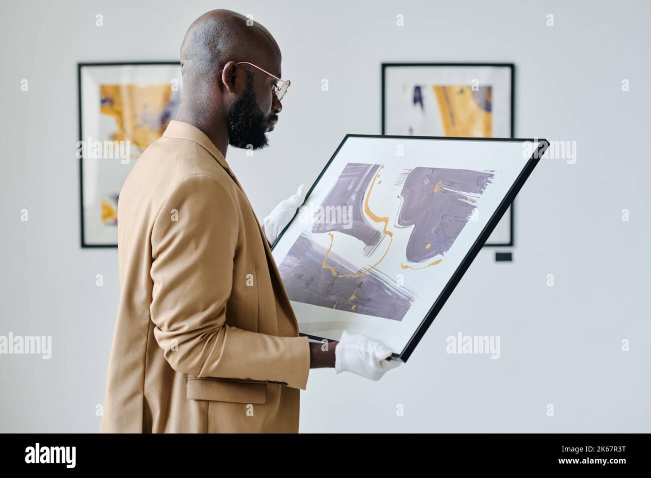 Un travailleur africain examine une photo entre ses mains lors de la préparation de l'exposition à la galerie d'art Banque D'Images