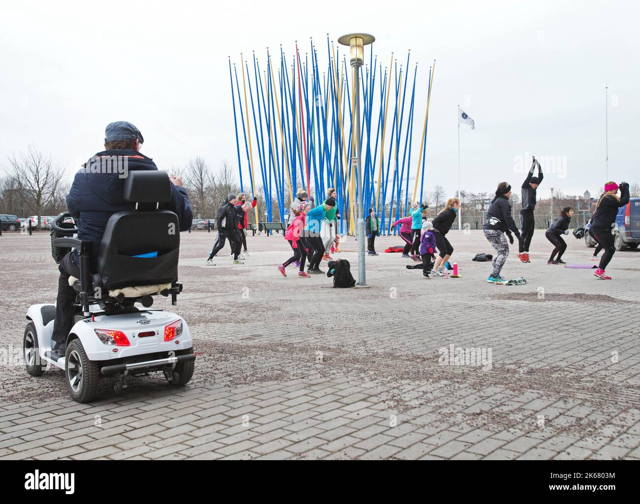 Méthode Tabata, une forme de formation à intervalles de haute intensité, ici en dehors de l'arène Saab, Linköping, Suède. En arrière-plan : les mâts de drapeaux et les œuvres d'art à l'extérieur de l'arène Saab, Linköping, Suède. Design par l'artiste Kari Cavén. Banque D'Images