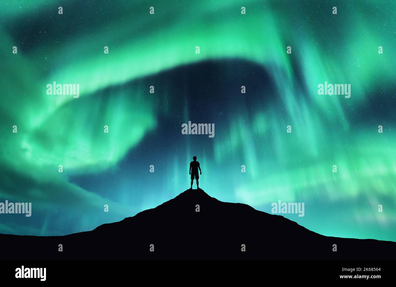 Lumières du nord et silhouette d'homme debout sur la montagne Banque D'Images