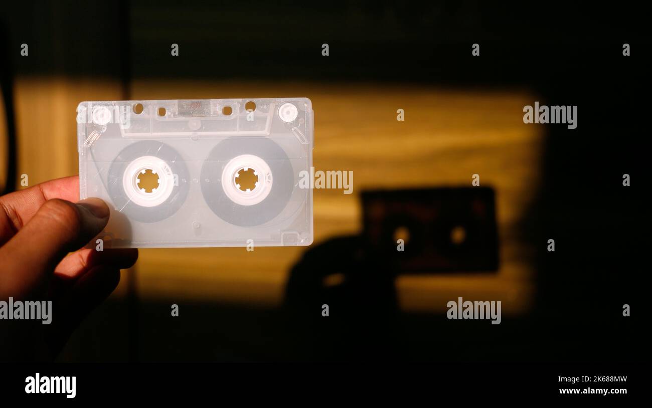 Gros plan de la main tenant la cassette audio blanche transparente Banque D'Images