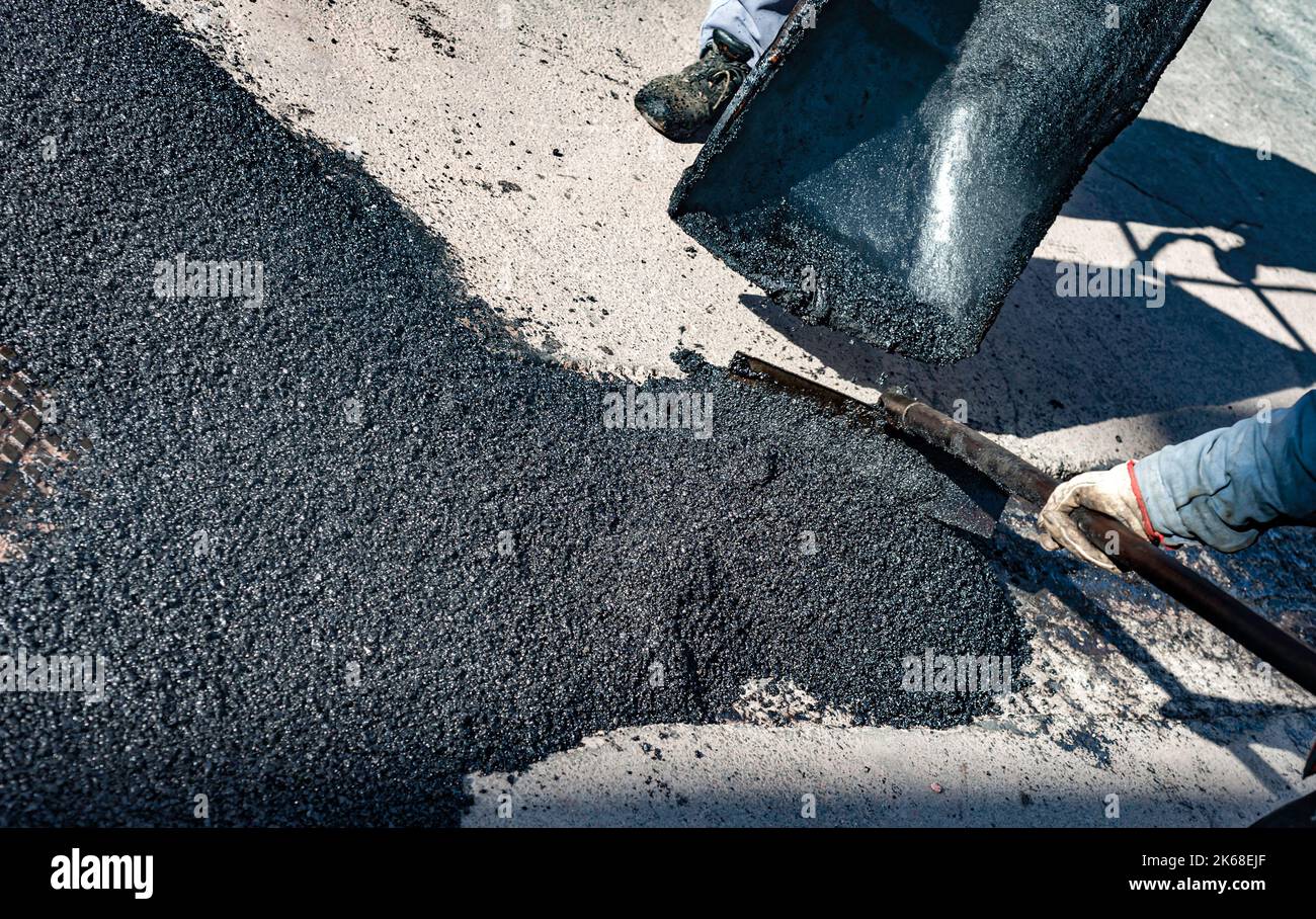 Frais de mise à niveau du travailleur au cours d'asphalte asphalte réparer ou de travaux de construction Banque D'Images