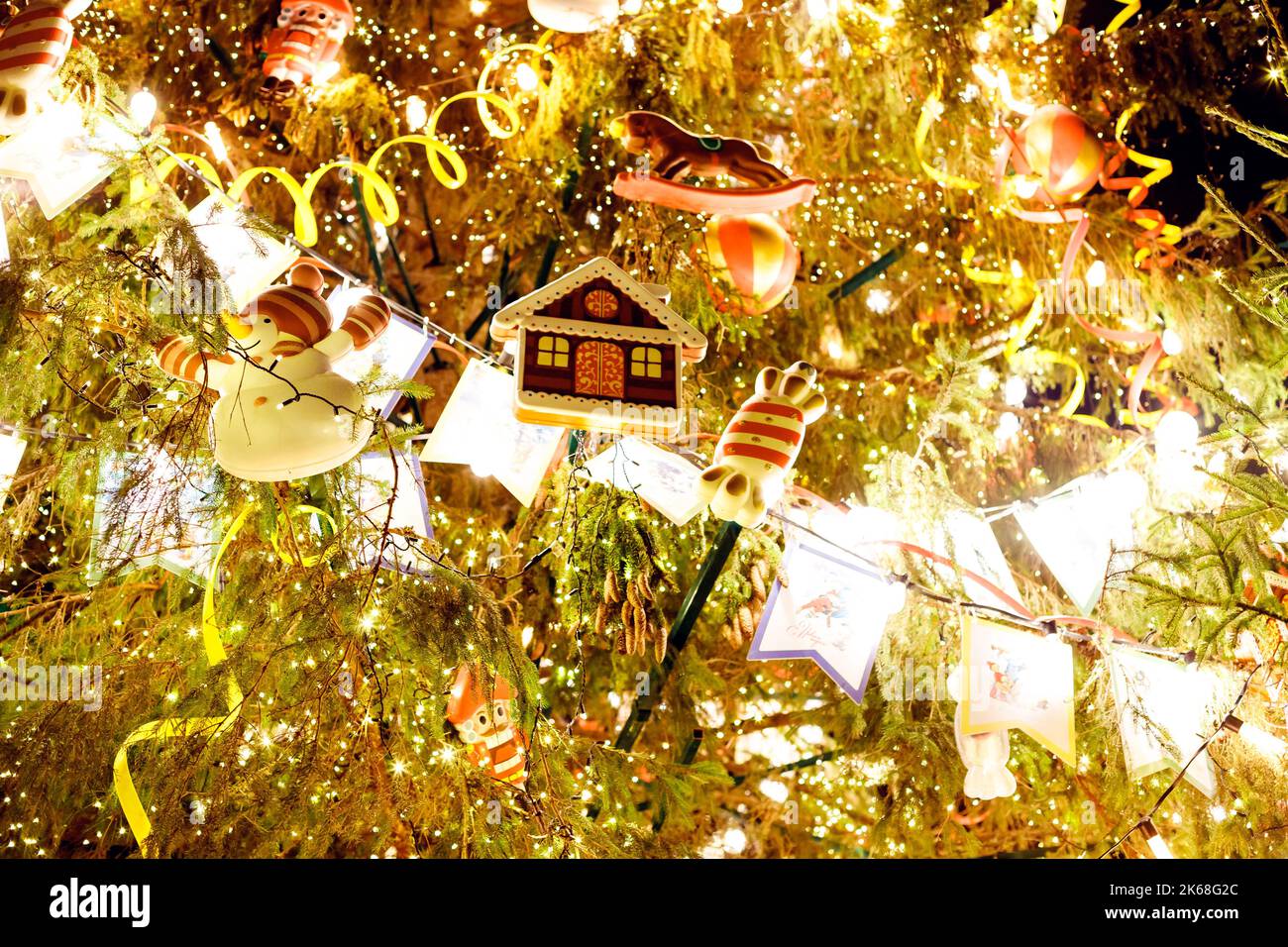 Sapin de Noël vintage aux riches décorations. Décoration de Noël suspendue  sur branche d'arbre. Guirlande lumineuse et lumières dorées. Jouets rétro  et guirlande lumineuse Photo Stock - Alamy