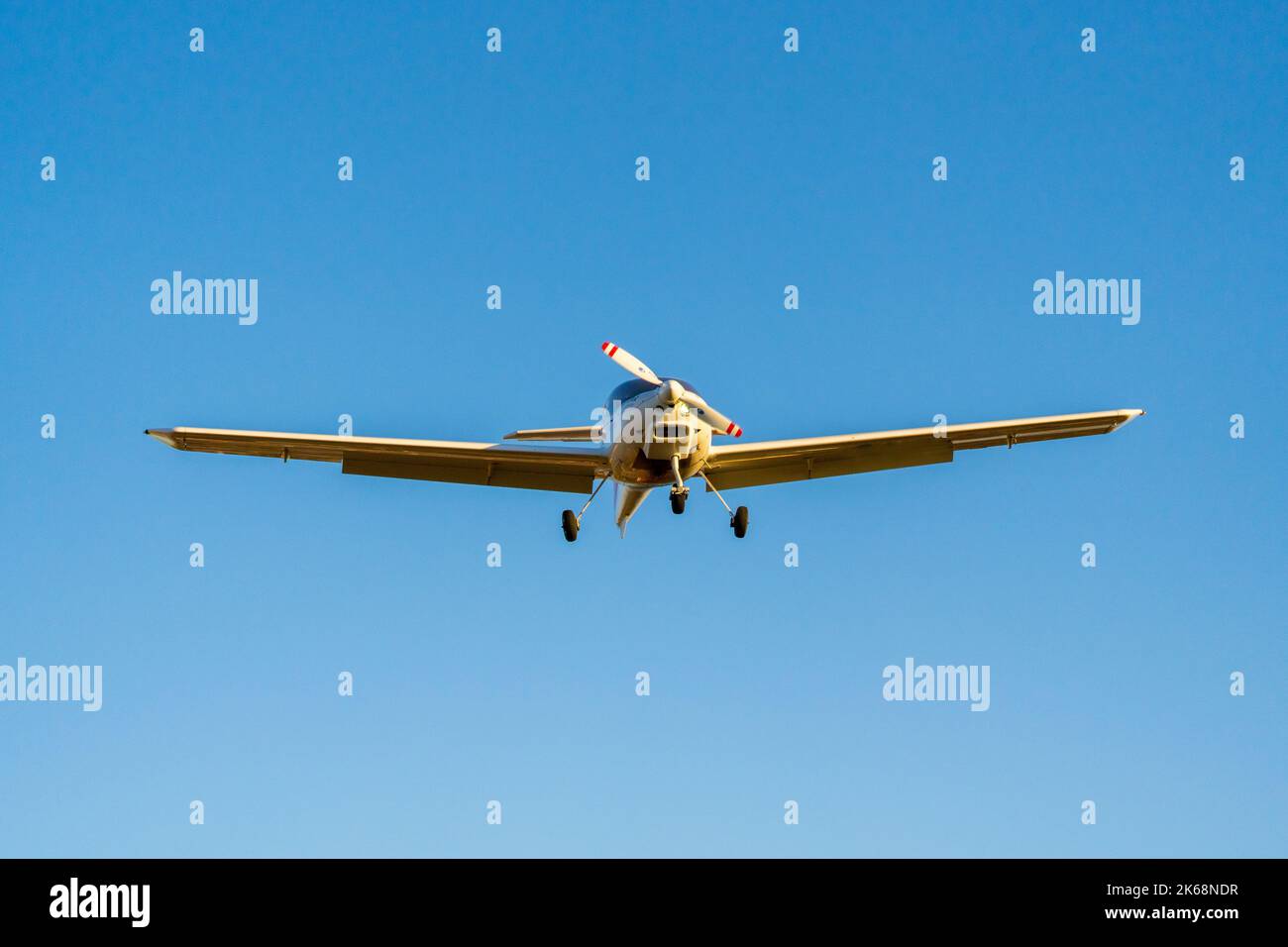 Avion à hélice unique qui atterrit d'une vue de face dans un ciel bleu Banque D'Images
