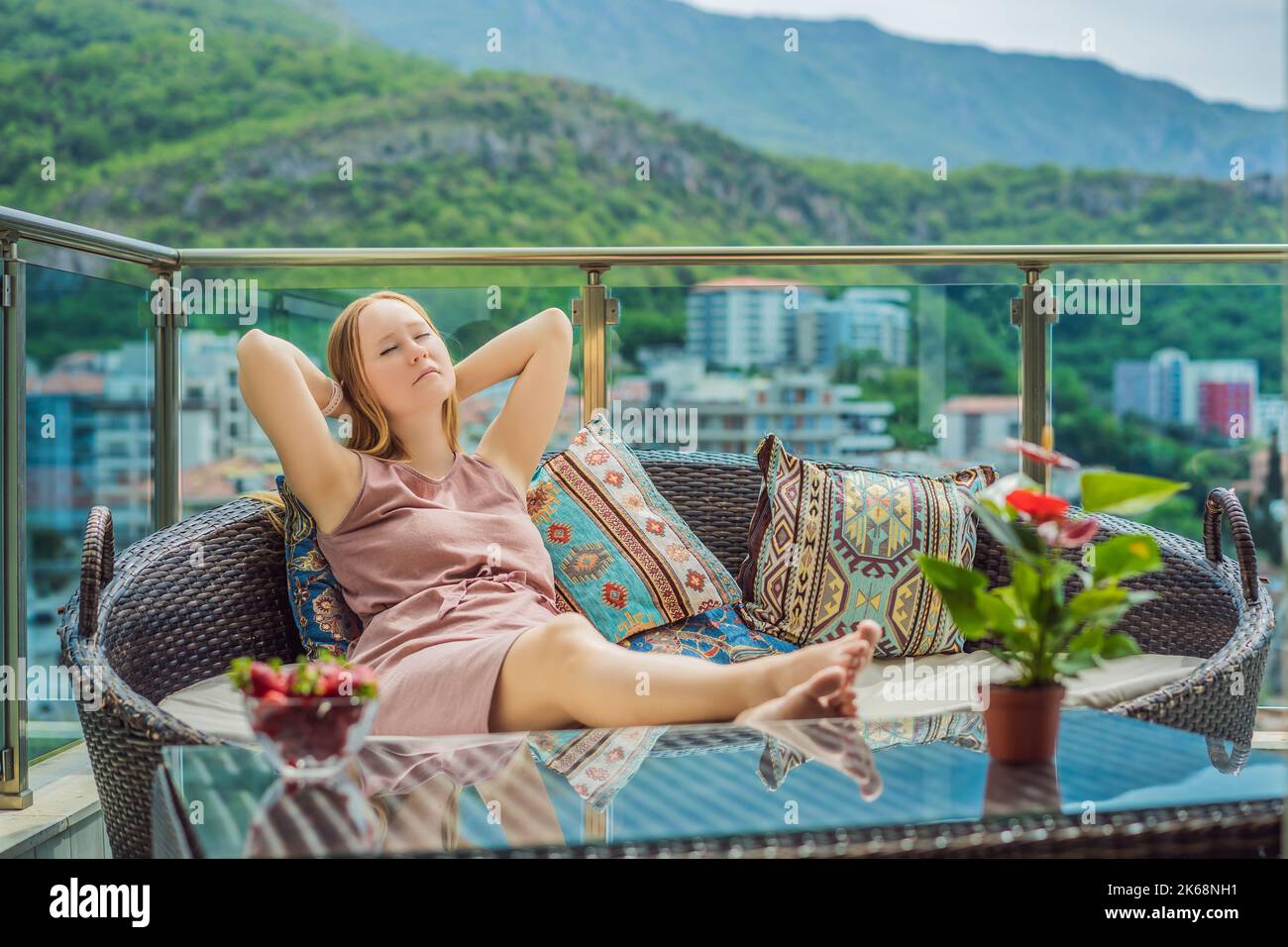 Maison style de vie femme détente dormir sur le canapé sur le patio extérieur salon. Bonne dame couchée sur des oreillers confortables et prenant une sieste pour le bien-être Banque D'Images