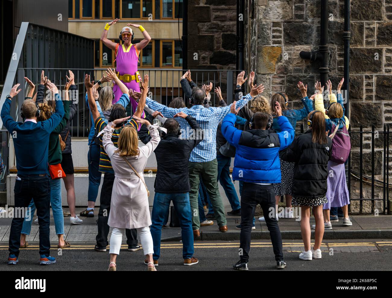 Des personnes dansant dans la rue lors d'un événement Silent Disco Fringe lors du festival d'Édimbourg Fringe Scotland, Royaume-Uni Banque D'Images