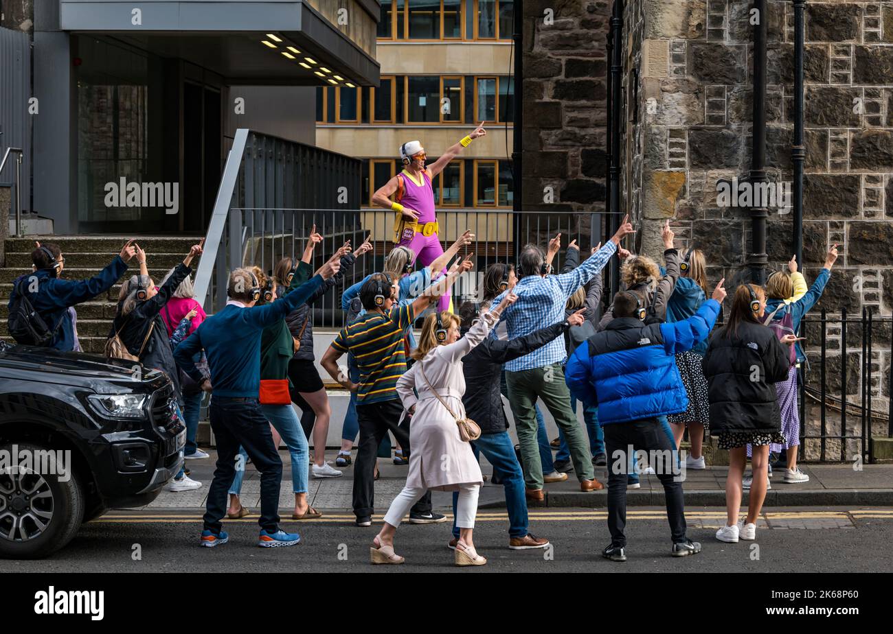 Des personnes dansant dans la rue lors d'un événement Silent Disco Fringe lors du festival d'Édimbourg Fringe Scotland, Royaume-Uni Banque D'Images
