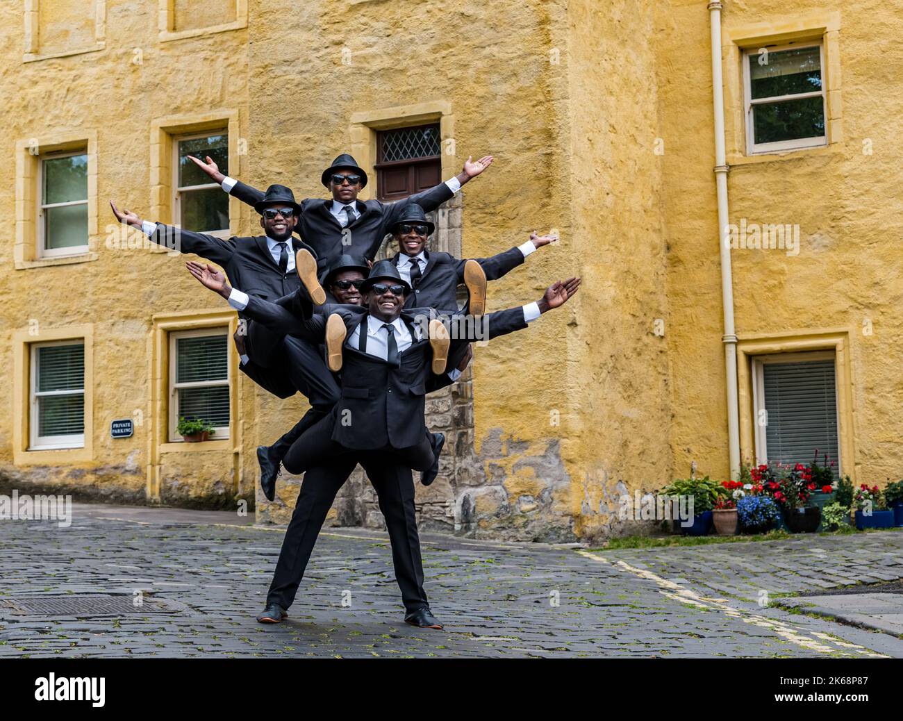 Le groupe acrobatique Black Blues Brothers se présente dans Dean Village, créant une pyramide humaine, à Édimbourg, en Écosse, au Royaume-Uni Banque D'Images