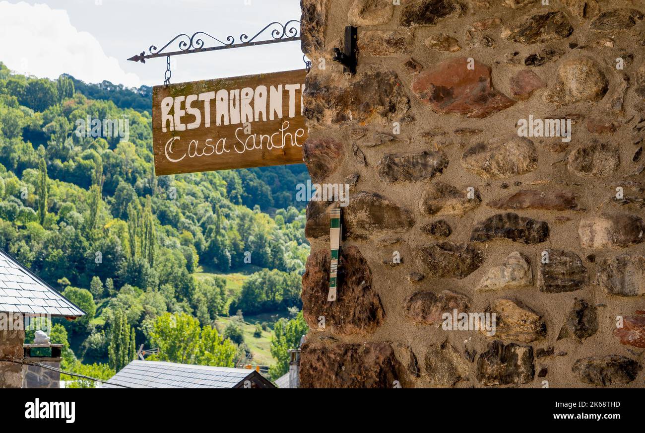 Panneau de restaurant en bois suspendu sur un bâtiment traditionnel du village espagnol, montagnes des Pyrénées, Espagne Banque D'Images