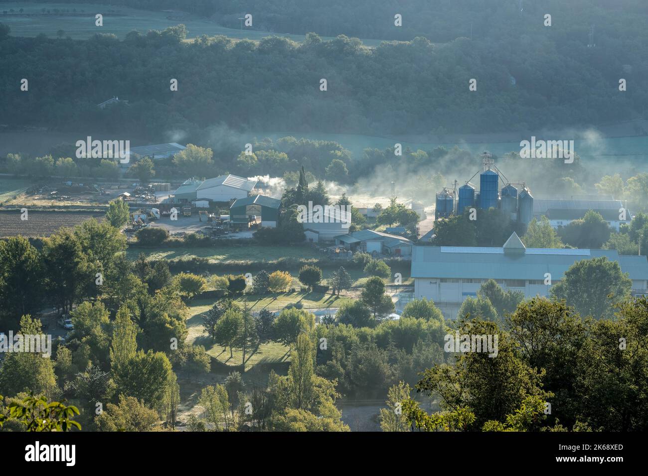 Ferme et usine dans une vallée, vapeur dans l'air froid du matin, Pyrénées, Espagne Banque D'Images