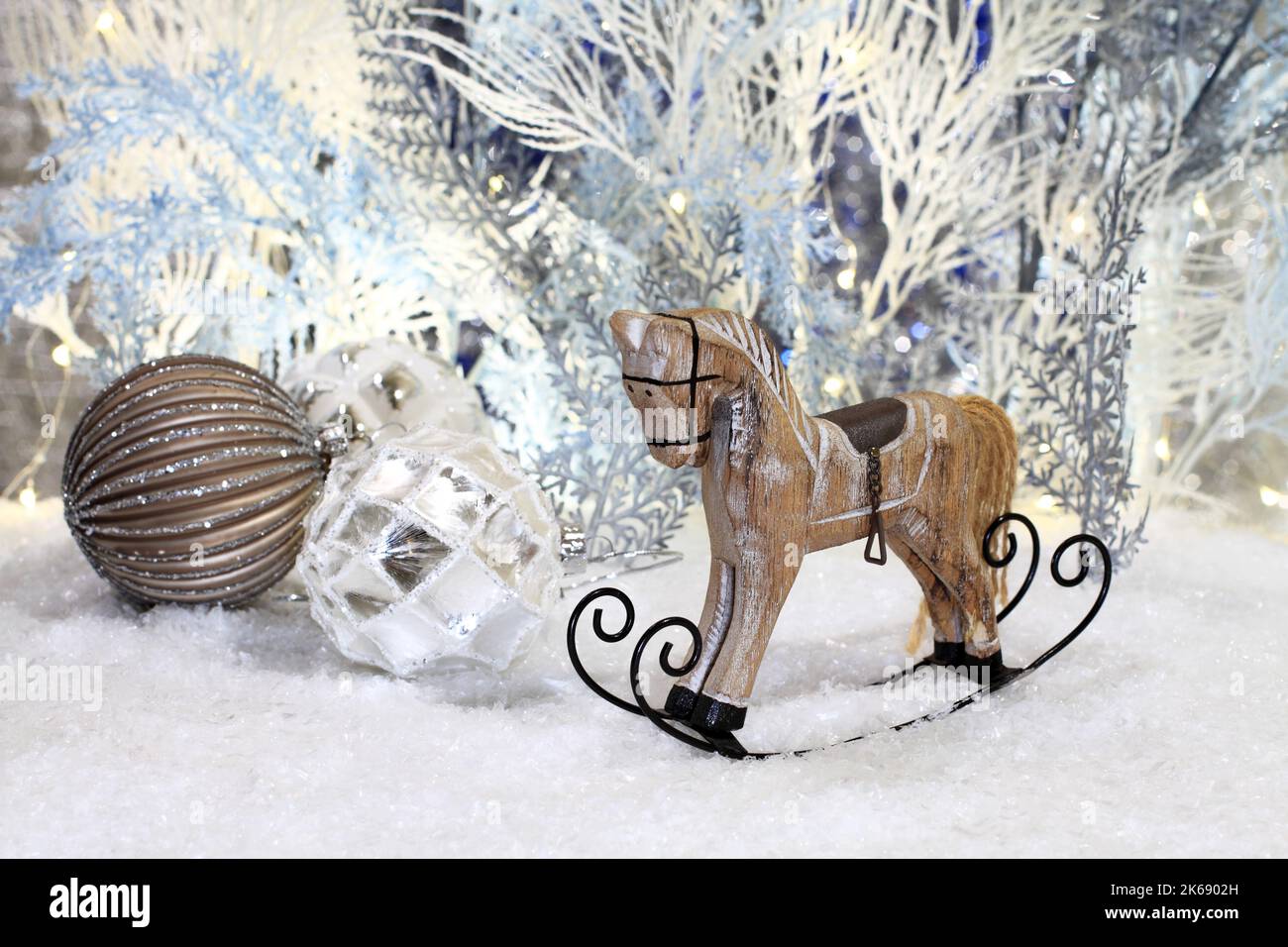 Les jouets de Noël se trouvent sur la neige artificielle sur fond d'arbres artificiels bleus et blancs. Gros plan. Prise de vue en studio de nuit. Banque D'Images