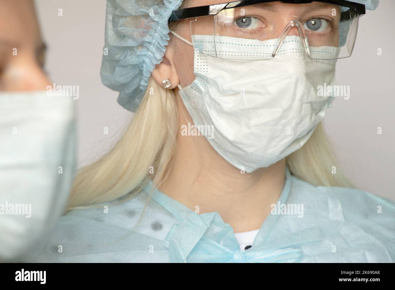 médecin fille dans un masque médical sur fond blanc, un travailleur médical sur fond isolé Banque D'Images