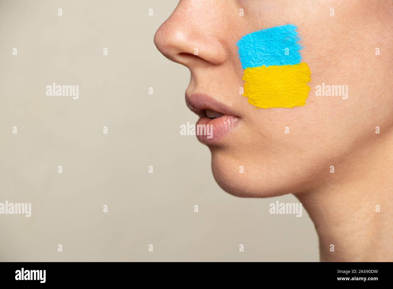 Le visage d'une fille avec le drapeau national de l'Ukraine jaune-bleu sur son visage, patriote, la paix en Ukraine, la loi martiale Banque D'Images