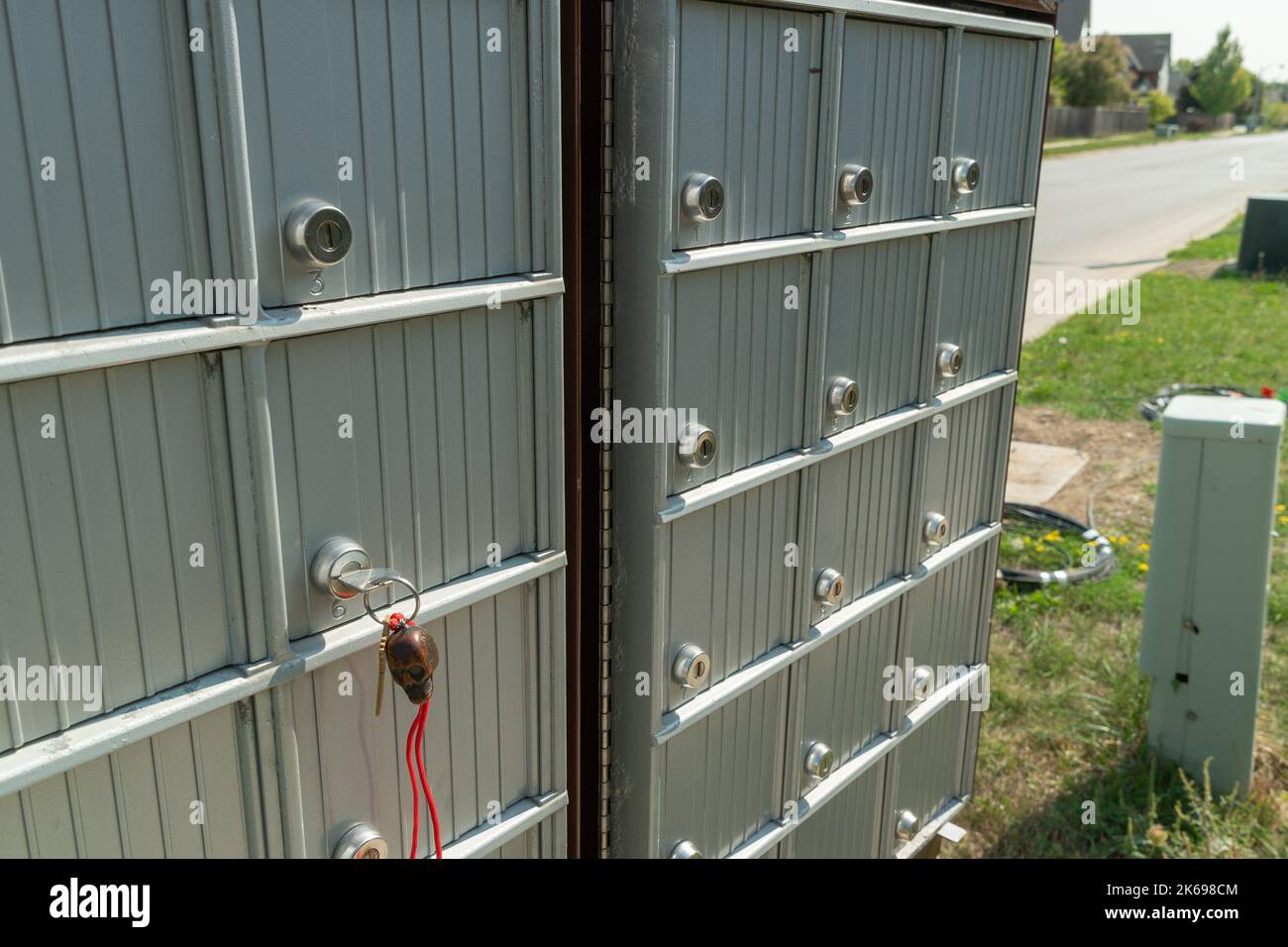 Une clé avec un fil rouge dans le verrou dans l'une des boîtes aux lettres situées près de la route dans la zone de la ville Banque D'Images