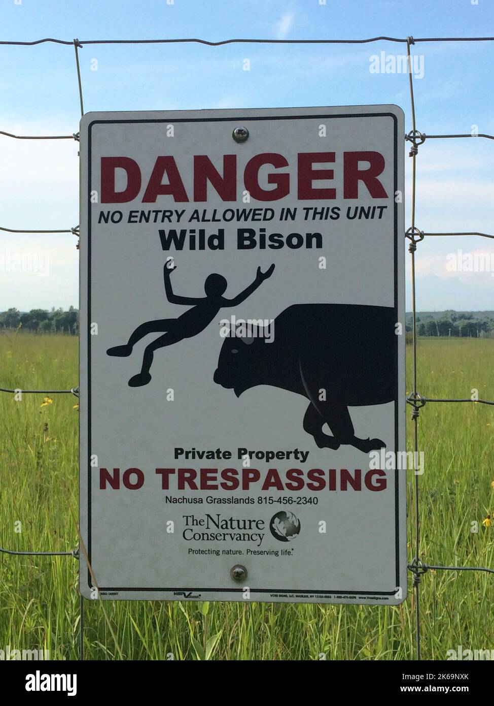 Des panneaux d'avertissement sur les bisons sont postés sur les clôtures entourant l'enclos de bisons à Nachusa Gasslands nature Conservancy, dans les comtés de Lee et d'Ogle, en Illinois Banque D'Images