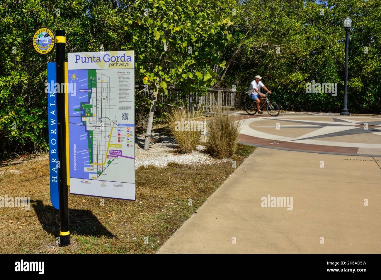 Panneau Harborwalk pour la ville de Punta Gorda avec carte avec Bicyclist appréciant les chemins à Trabue Park sur le Harborwalk à Punta Gorda, Floride Banque D'Images