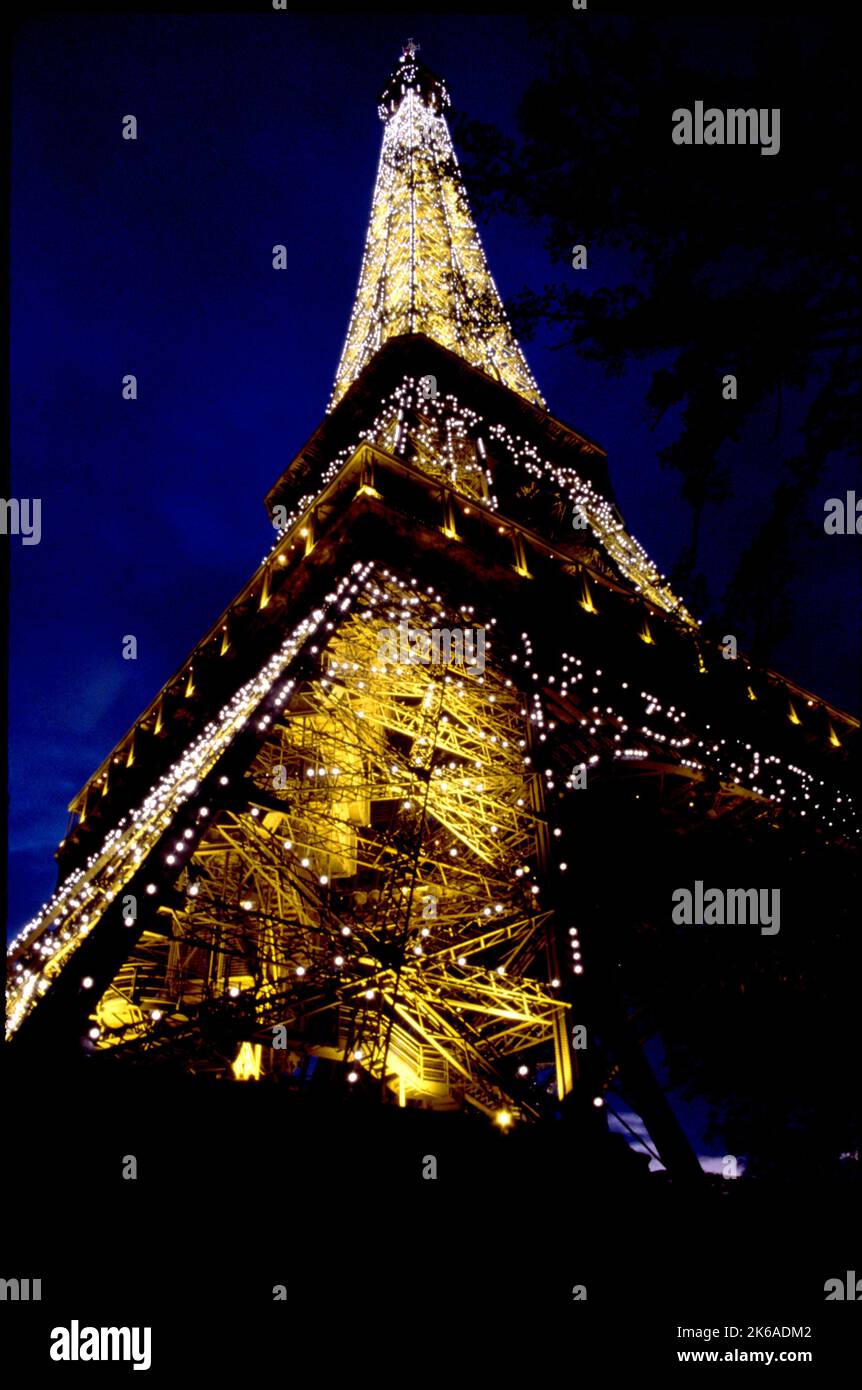 Des lumières étincelantes clignotent depuis la Tour Eiffel à Paris au crépuscule. Banque D'Images