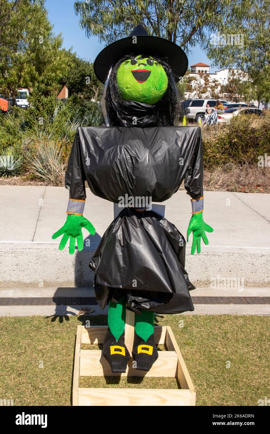 Une sorcière à l'arnaque faite de sacs poubelles noirs sourit à un festival d'Halloween dans un parc de Costa Mesa, CA. Banque D'Images