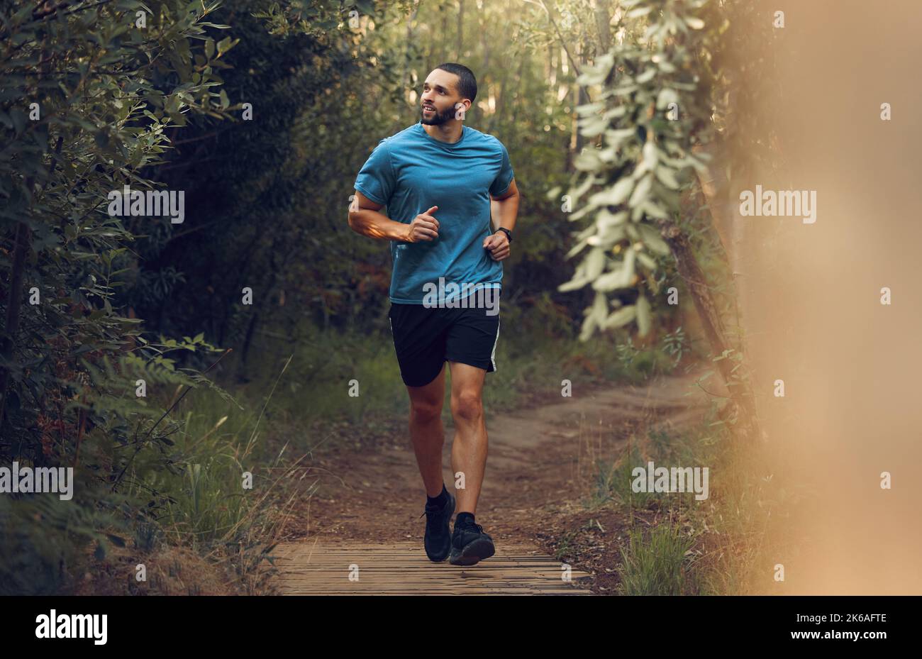 Course à pied, homme de fitness et forêt courez sur un sentier pour l'exercice, l'entraînement et l'entraînement dans la nature pour la santé et le bien-être. Athlète homme de jogging ou actif Banque D'Images