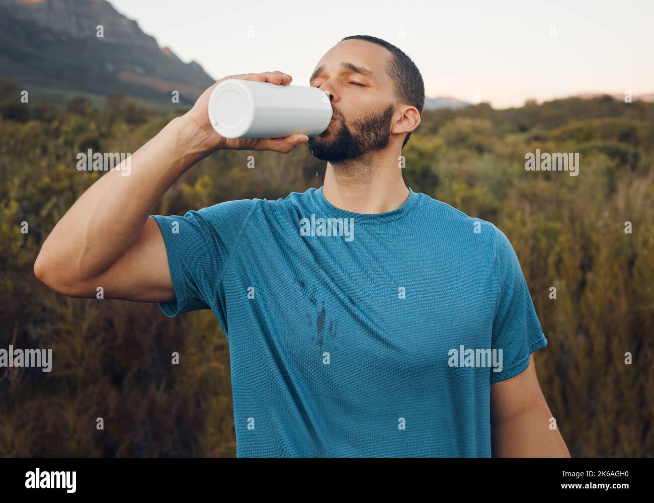Santé, montagne et eau potable avec l'homme dans la nature pour la forme physique, le bien-être et de détente après la course. Entraînement, exercice et sports avec le coureur Banque D'Images
