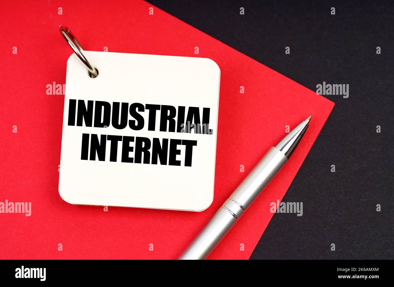 Concept d'industrie et d'entreprise. Sur un fond noir et rouge se trouve un stylo et un carnet avec l'inscription - Internet industriel Banque D'Images