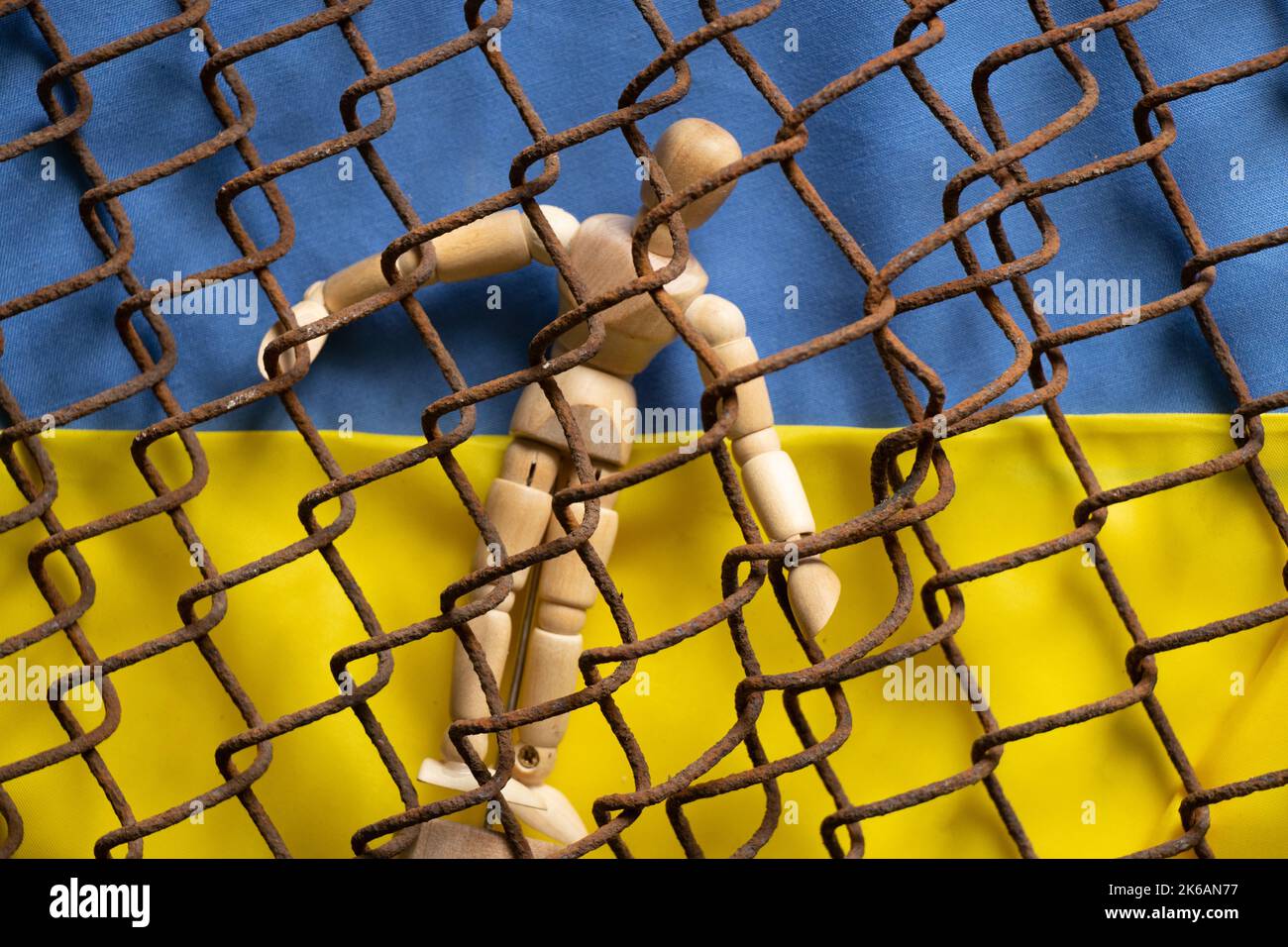 Drapeau national jaune et bleu de l'Ukraine et homme en bois sur fond de fil de fer rouillé, arrêter la guerre et la paix en Ukraine 2022 Banque D'Images