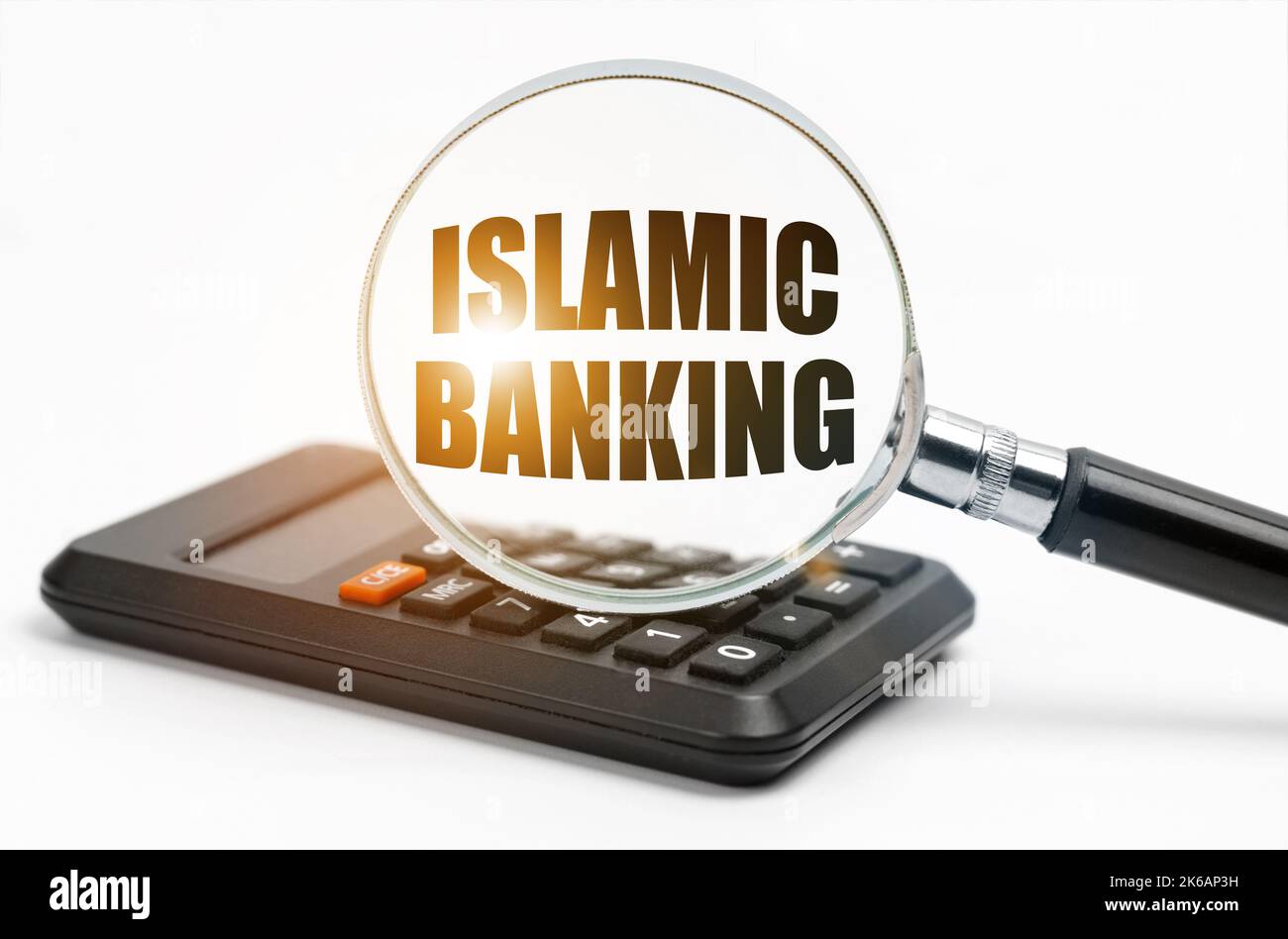 Concept commercial et financier. Sur la table se trouve une calculatrice et une loupe, à l'intérieur de laquelle l'inscription - Banque islamique Banque D'Images