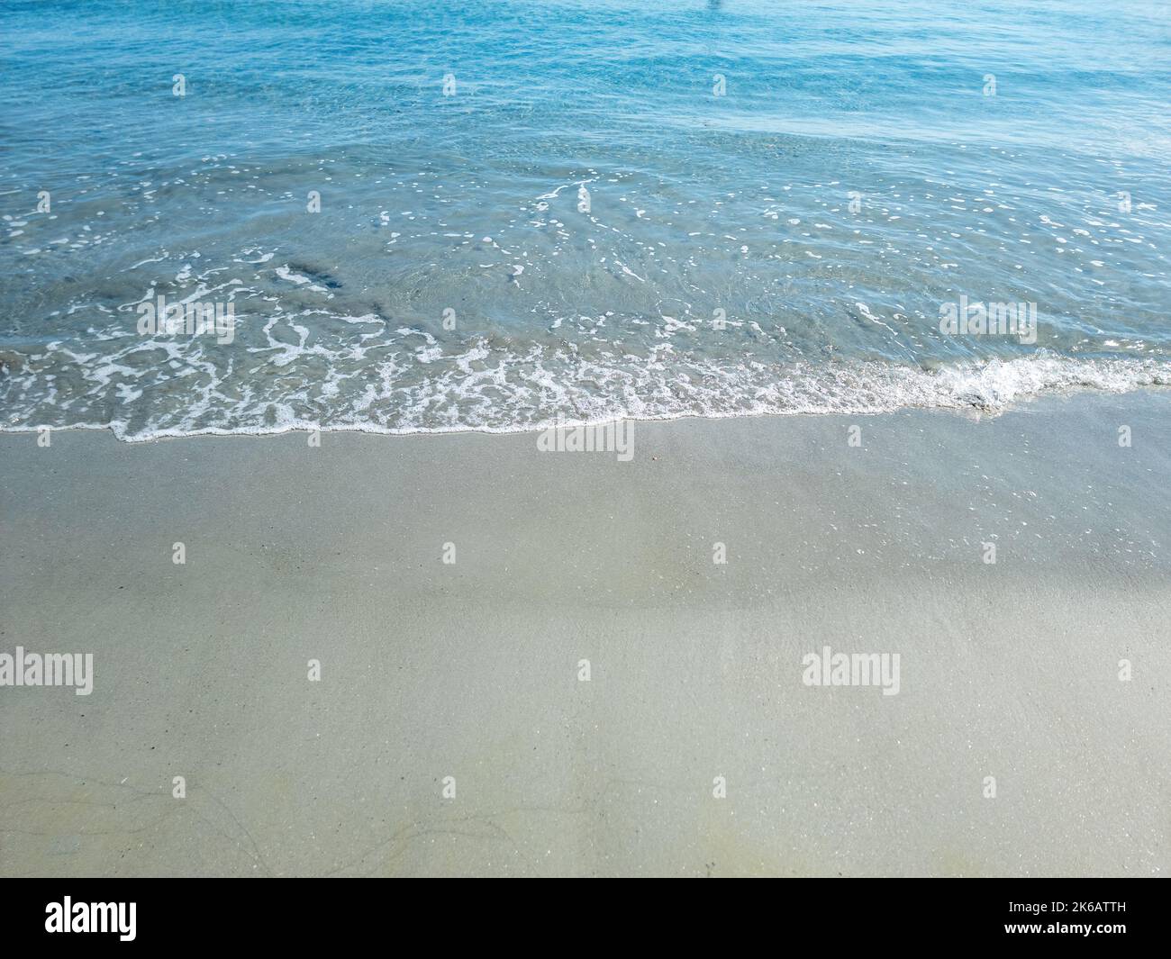 Eau d'ondulation de mer sur sable humide. Plage de sable vide, destination île grecque Cyclades, Grèce. Modèle de vacances d'été, espace, vue de dessus. Banque D'Images