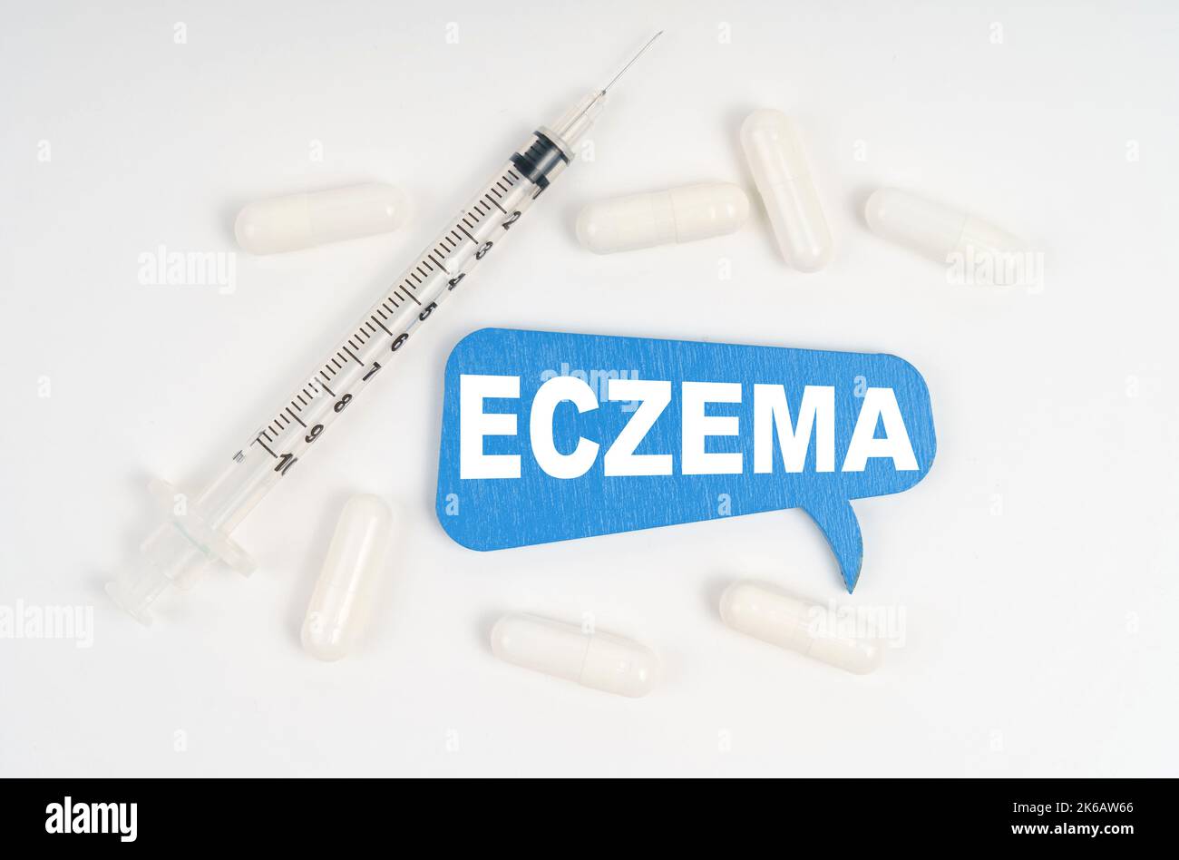 Médecine et concept de santé. Sur fond blanc, une seringue et une plaque bleue avec l'inscription - ECZÉMA Banque D'Images Médecine et concept de santé. Sur fond blanc, une seringue et une plaque bleue avec l'inscription - ECZÉMA Banque D'Images