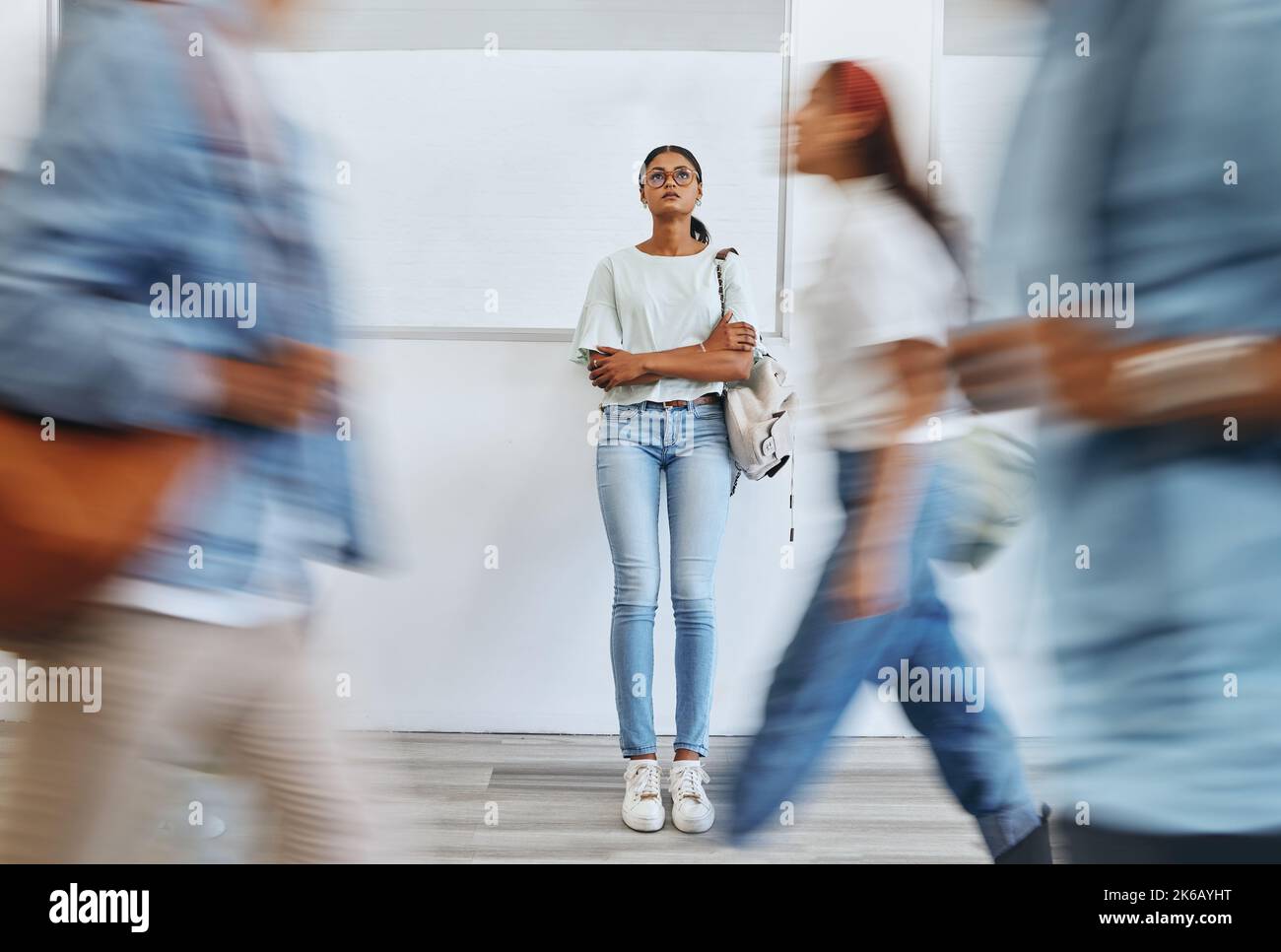 Étudiant, anxiété et femme dans un campus universitaire occupé avec dépression, triste et des problèmes de santé mentale. Burnout, stress et fille fatiguée pensant à l'examen Banque D'Images