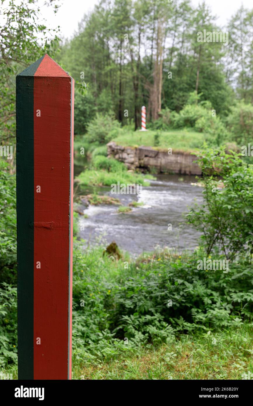 Poteaux frontaliers sur la frontière entre la Pologne et le Belarus sur le fleuve Svisloch. Tir vertical. Concentrez-vous sur le pôle de la frontière biélorusse. Banque D'Images