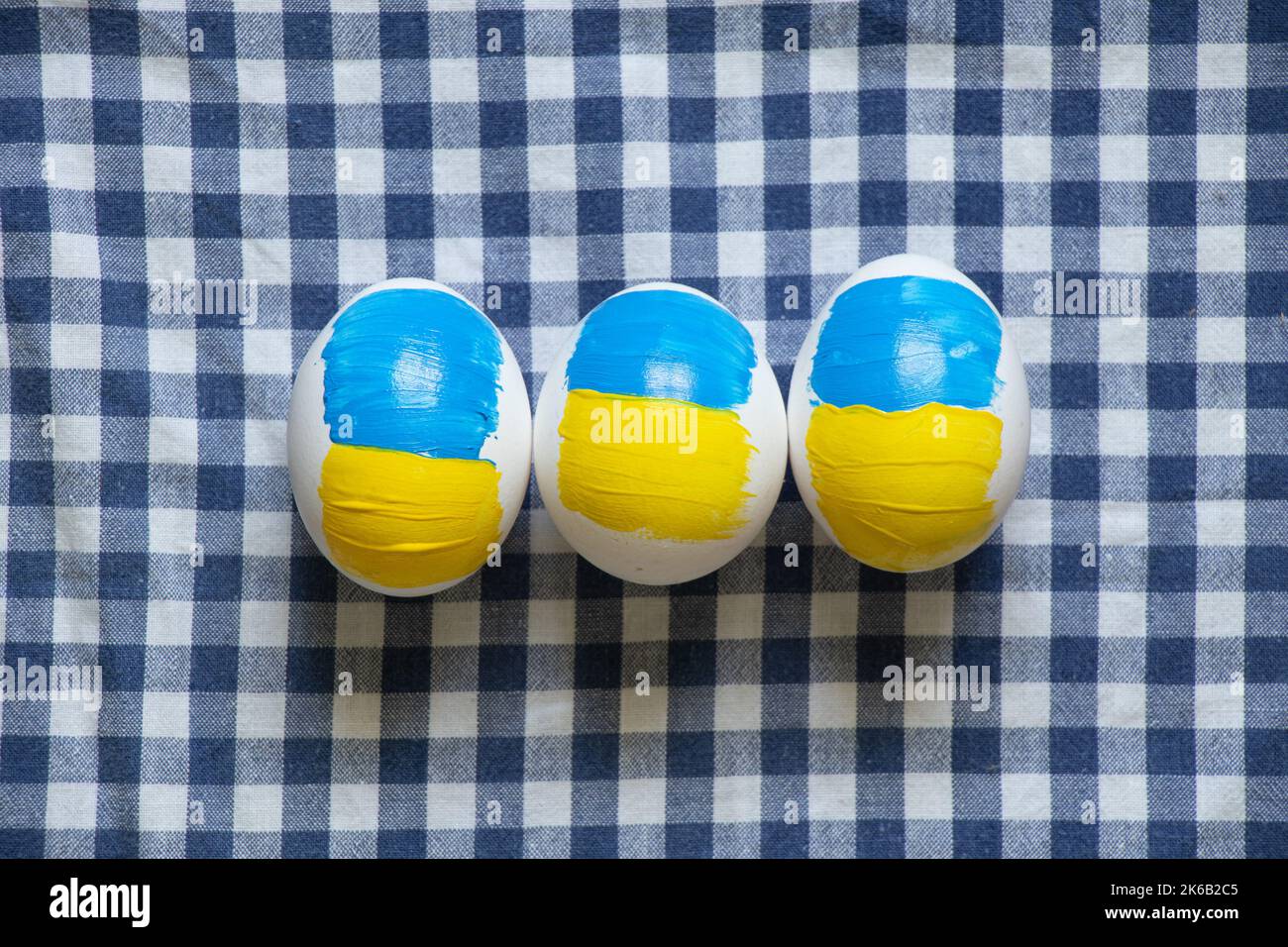 Oeuf de poulet blanc avec un drapeau peint de l'Ukraine sur la table à la maison, la culture et les vacances 2022 dans la guerre en Ukraine Banque D'Images