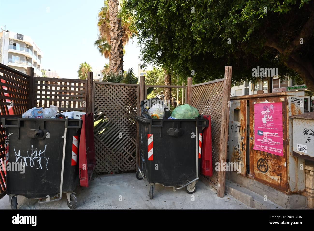 Grandes poubelles en plastique sur roues pleines de sacs en plastique