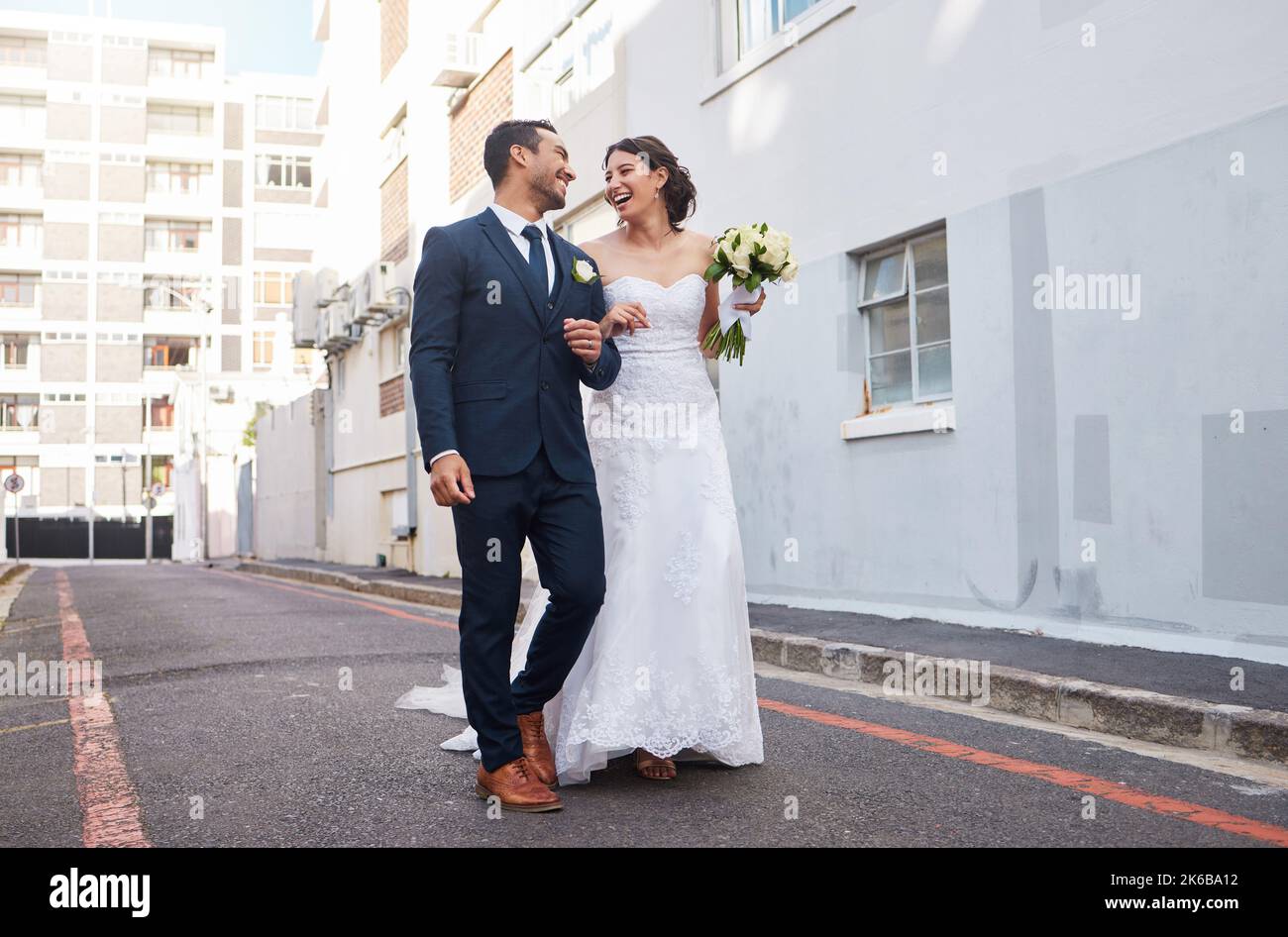 Être profondément aimé par quelqu'un vous donne la force. Un beau couple marchant dans la ville le jour de leur mariage. Banque D'Images