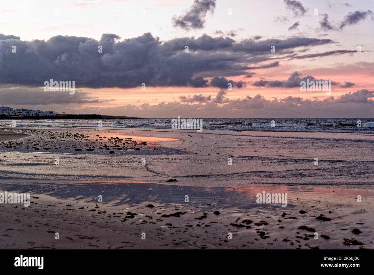 Coucher de soleil sur Famara Beach. Lanzarote îles Canaries Caleta de Famara, plage de Famara planche à voile et plage de surf dans la lumière du soir. Banque D'Images