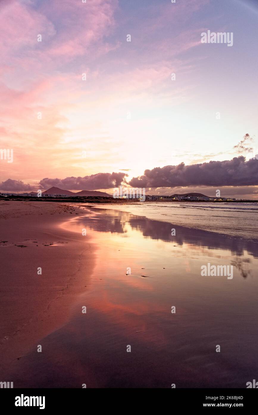 Coucher de soleil sur Famara Beach. Lanzarote îles Canaries Caleta de Famara, plage de Famara planche à voile et plage de surf dans la lumière du soir. Banque D'Images