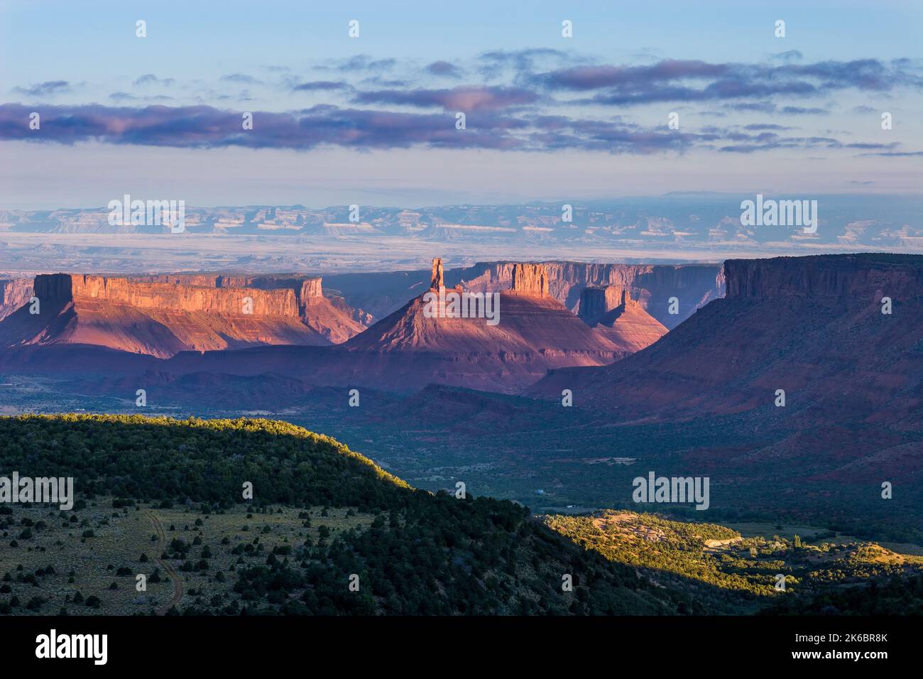 Castleton Tower / Castle Rock et le presbytère au premier feu au lever du soleil près de Moab, Utah. Vous trouverez également Pariott Mesa, à gauche, et Adobe Mesa à droite. T Banque D'Images
