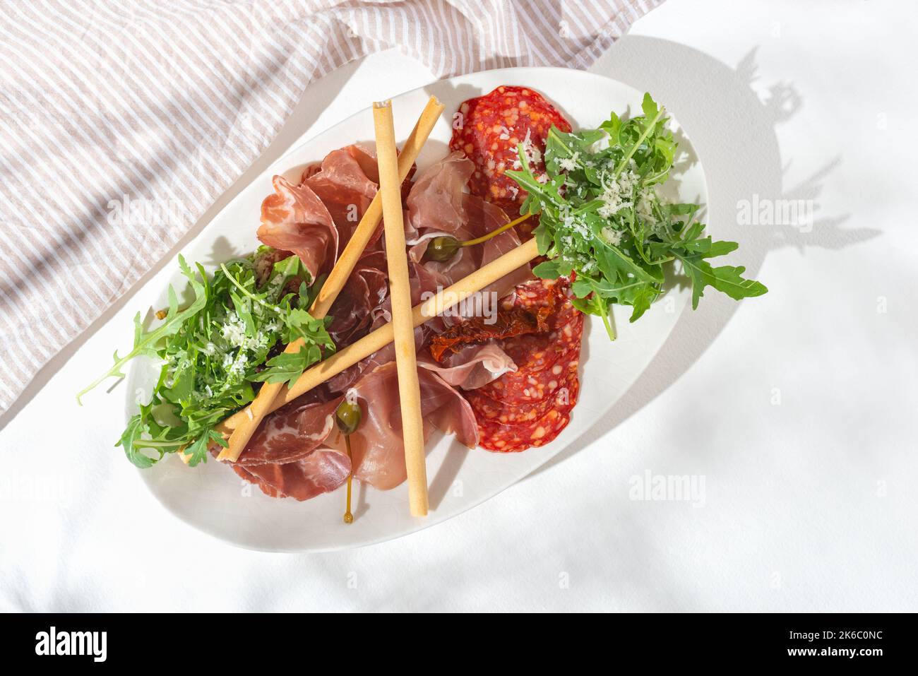 Gastronomie de la viande. Hors-d'œuvre avec différents antipasti, prosciutto crudo, bresaola, Napoli Piccante salami, grissini, tomates séchées au soleil, câpres sur le mert Banque D'Images