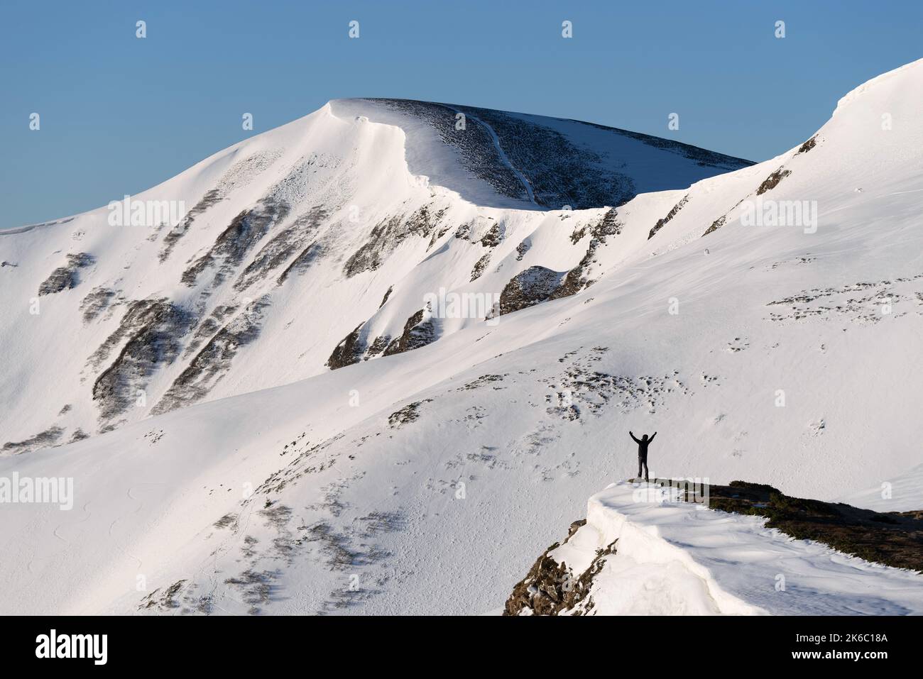 Un homme en randonnée d'hiver bénéficie de la vue sur les montagnes dans la neige Banque D'Images