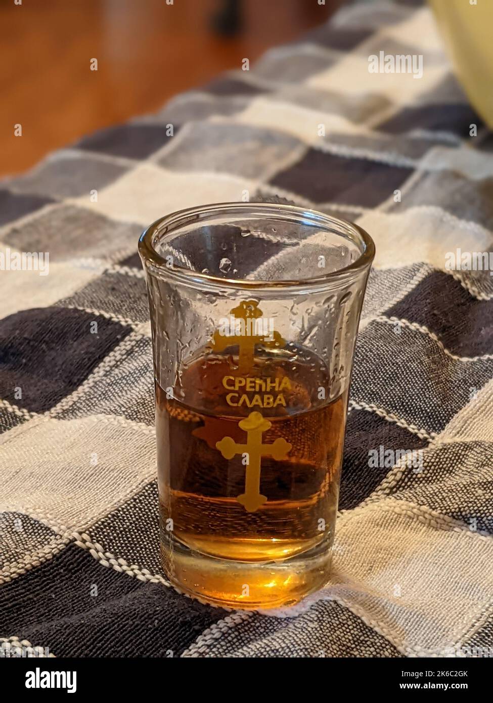 Un gros plan vertical du verre de whisky avec l'inscription et la croix. Banque D'Images