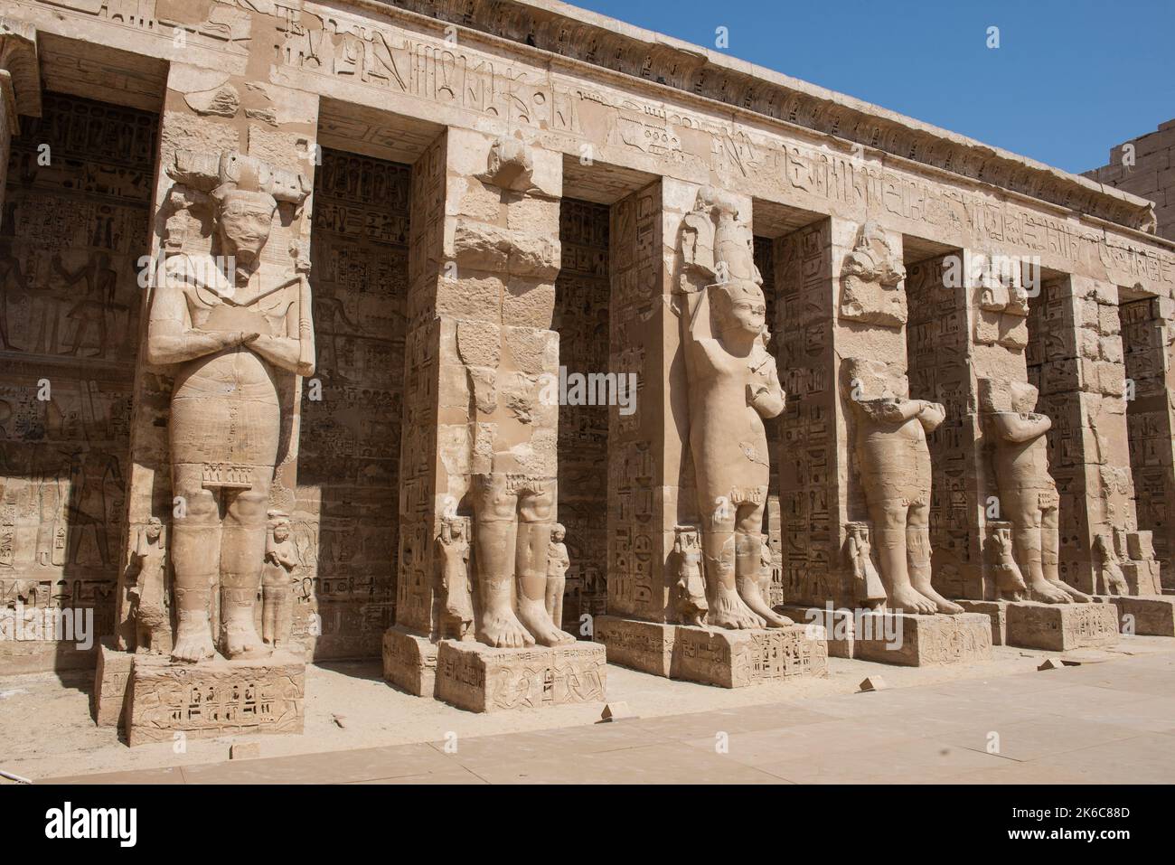 Grandes statues de Ramses II dans l'ancien Temple égyptien Medinat Habu avec des colonnes dans la cour Banque D'Images