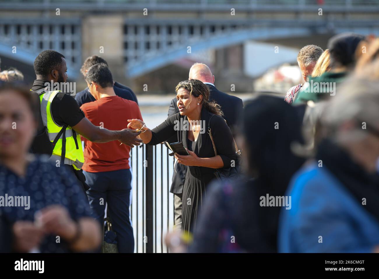 Les membres du public recevant des bracelets alors qu'ils se joignent à la file d'attente le premier jour pour visiter la Reine située dans l'État à Westminster Hall Londres Royaume-Uni. Banque D'Images