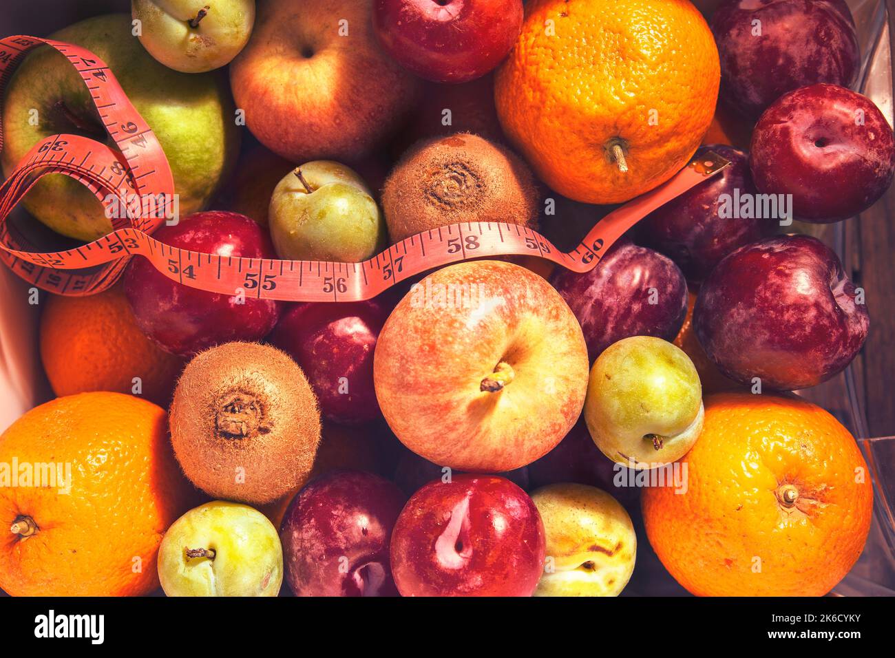 fruits d'été empilés à côté d'un mètre ruban Banque D'Images