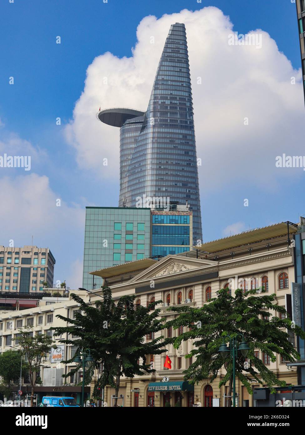 gratte-ciel au vietnam avec vue sur la rue et bâtiment avec palmiers à l'avant et ciel bleu et nuages blancs en arrière-plan Banque D'Images