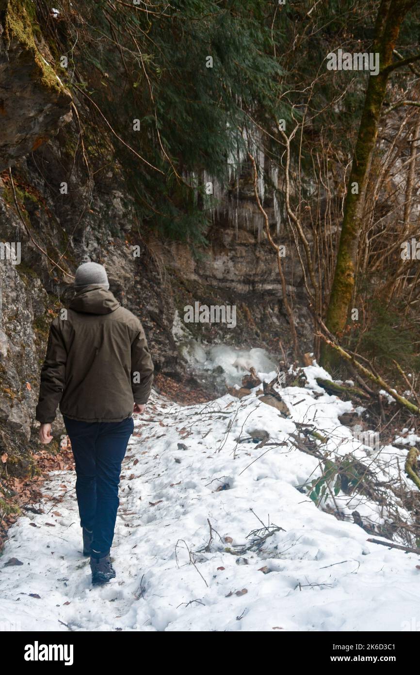 Un homme de derrière marche dans les montagnes pendant la neige et la saison d'hiver Banque D'Images