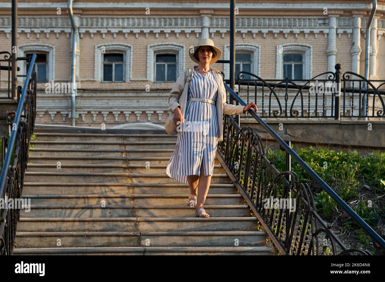 Femme descendant les escaliers dans la rue d'une petite ville Banque D'Images
