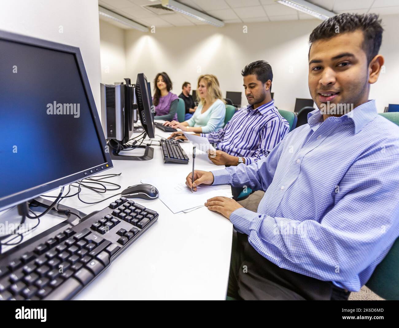 Éducation des adultes : à l'ordinateur. Des étudiants matures travaillent dans leur suite d'ordinateurs d'université. À partir d'une série d'images associées sur le sujet. Banque D'Images